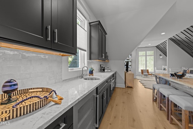 1208 Hunting Ridge Rd, Raleigh, NC 27615 - kitchen with a sink, dark cabinets, light wood-type flooring, open floor plan, and vaulted ceiling