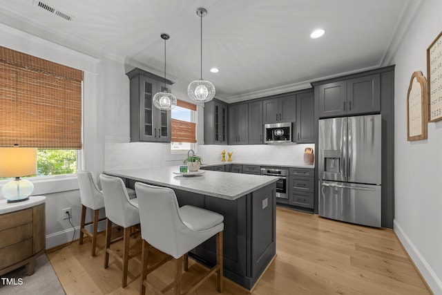 1208 Hunting Ridge Rd, Raleigh, NC 27615 - kitchen featuring stainless steel appliances, a peninsula, glass insert cabinets, crown molding, and a kitchen breakfast bar