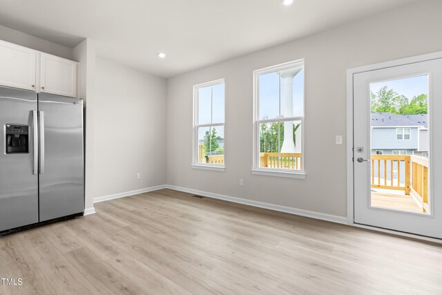 605 Silverado Sunset Loop, Wendell, NC 27591 - kitchen with stainless steel fridge, healthy amount of natural light, white cabinetry, baseboards, and recessed lighting