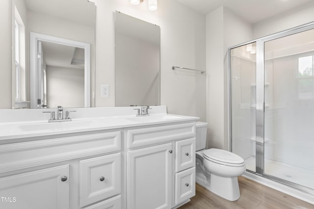 605 Silverado Sunset Loop, Wendell, NC 27591 - bathroom featuring double vanity, toilet, a stall shower, and wood finished floors