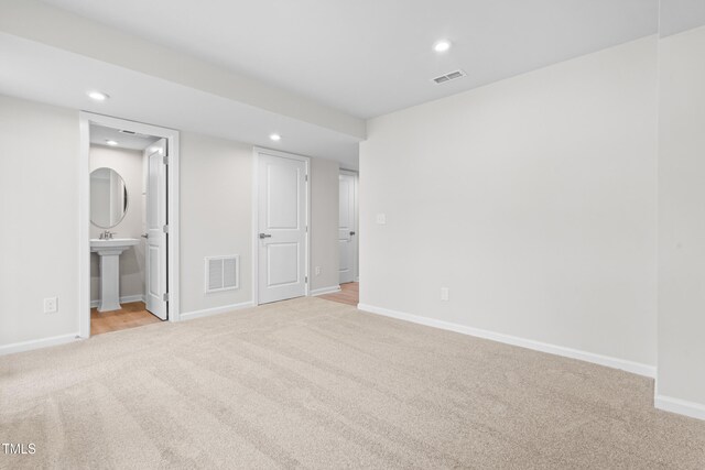 609 Silverado Sunset Loop, Wendell, NC 27591 - unfurnished bedroom with light colored carpet, recessed lighting, baseboards, a sink, and connected bathroom