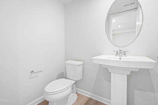 609 Silverado Sunset Loop, Wendell, NC 27591 - half bath with wood finished floors, toilet, baseboards, and a sink