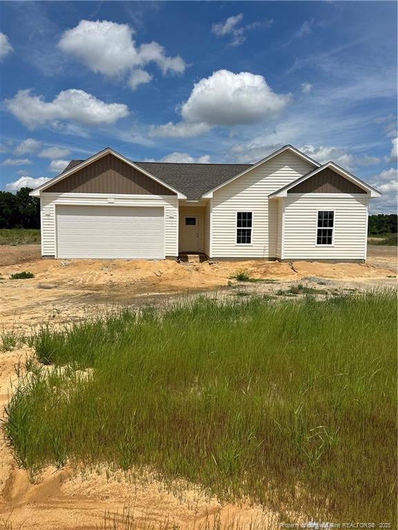 254 Dalton Dr, Lumber Bridge, NC 28357 - ranch-style house with dirt driveway, a garage, and a shingled roof