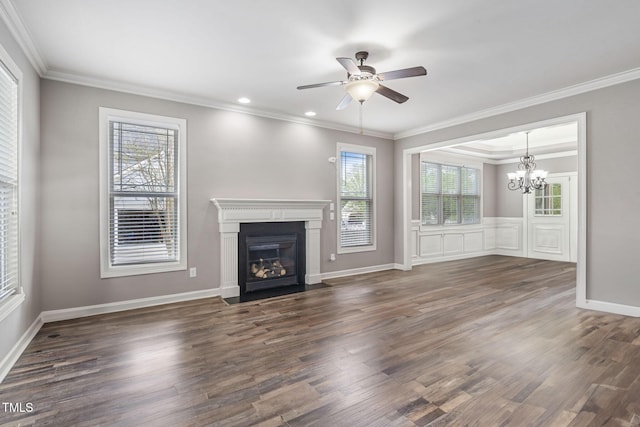 unfurnished living room featuring a chandelier, a ceiling fan, crown molding, wood finished floors, and a fireplace with flush hearth