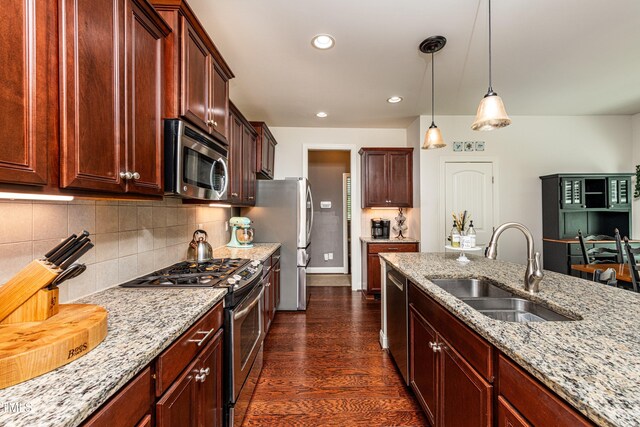 2739 Elderberry Ln, Apex, NC 27539 - kitchen featuring stainless steel appliances, a sink, light stone counters, dark wood finished floors, and recessed lighting