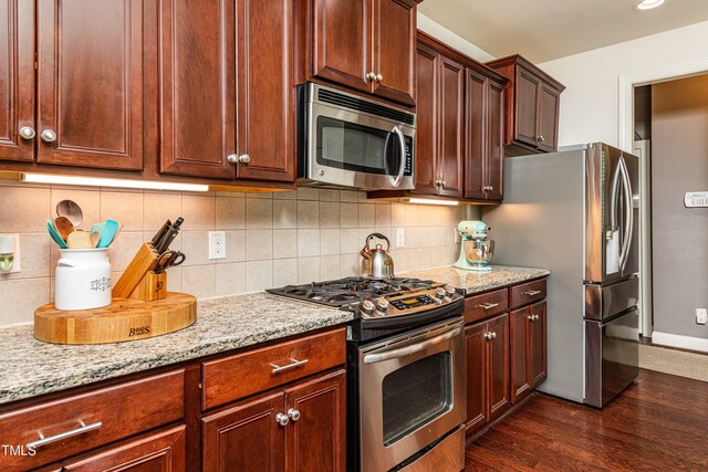 2739 Elderberry Ln, Apex, NC 27539 - kitchen with appliances with stainless steel finishes, light stone counters, dark wood-style flooring, and tasteful backsplash