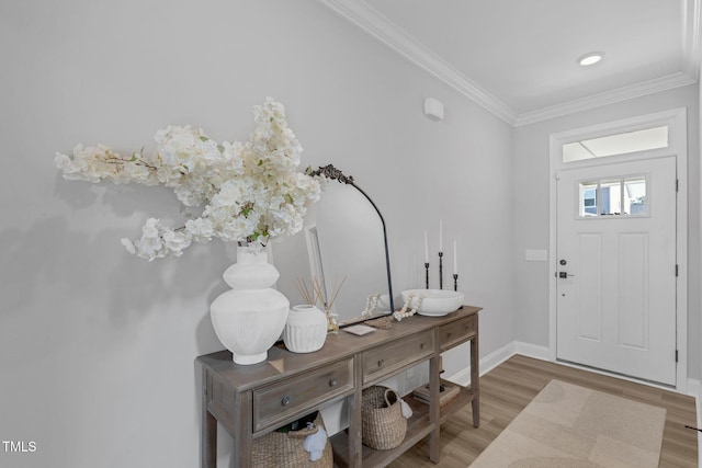 entrance foyer featuring baseboards, wood finished floors, and crown molding