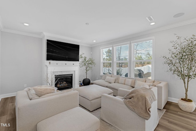 living area featuring ornamental molding and light wood finished floors
