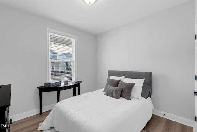 bedroom featuring baseboards and wood finished floors