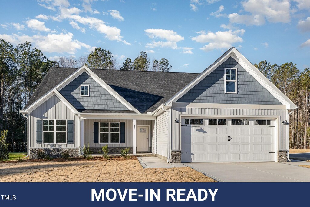 18 S Rowsham Pl, Smithfield, NC 27577 - view of front of home with board and batten siding, a garage, stone siding, a shingled roof, and concrete driveway