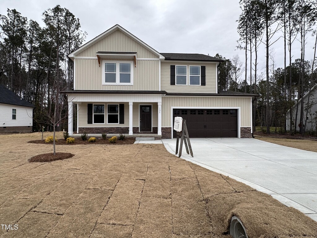 view of front of home featuring an attached garage, driveway, and a porch