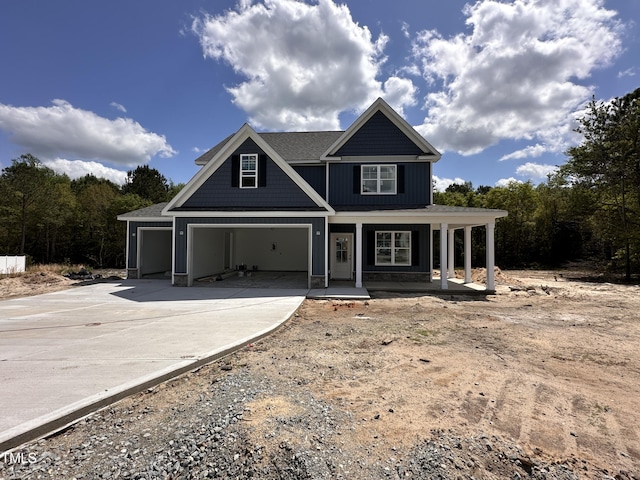view of front of property featuring concrete driveway, a garage, and covered porch