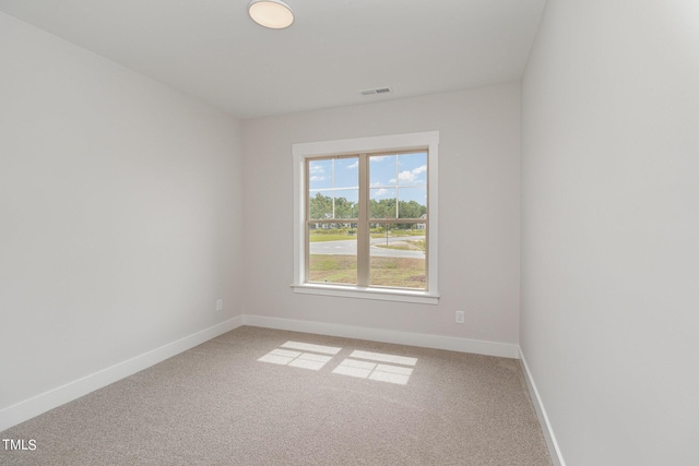 empty room featuring visible vents, baseboards, and light colored carpet
