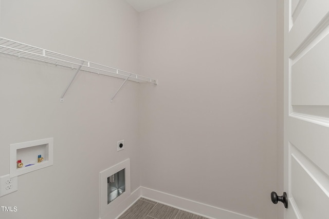 clothes washing area with laundry area, hookup for an electric dryer, washer hookup, and baseboards