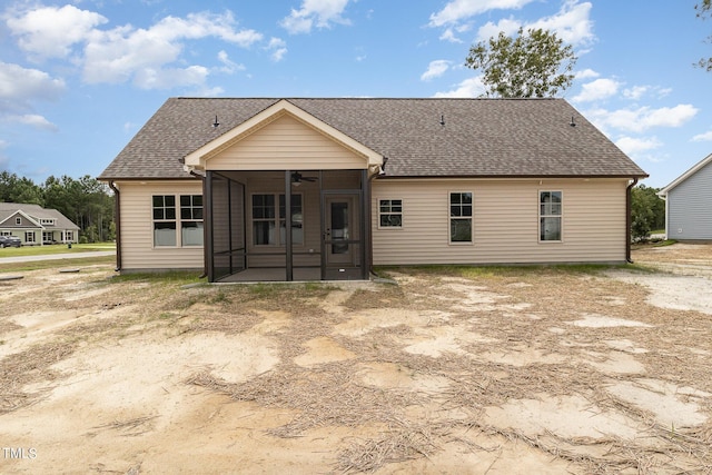 rear view of house with roof with shingles, a sunroom, and a ceiling fan
