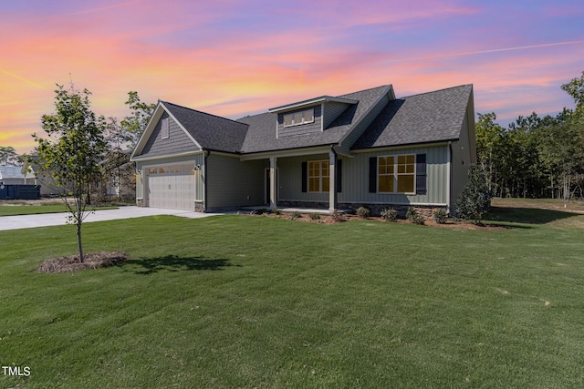 view of front facade with a lawn, a porch, roof with shingles, an attached garage, and concrete driveway