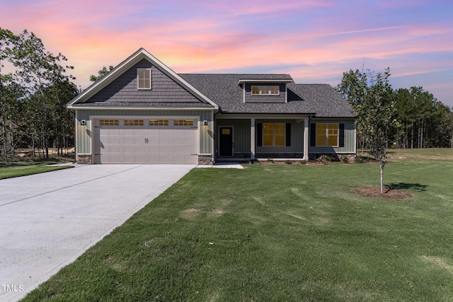 view of front of house featuring a lawn, driveway, an attached garage, a porch, and a shingled roof