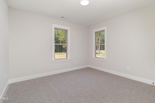 unfurnished room with visible vents, baseboards, and carpet flooring