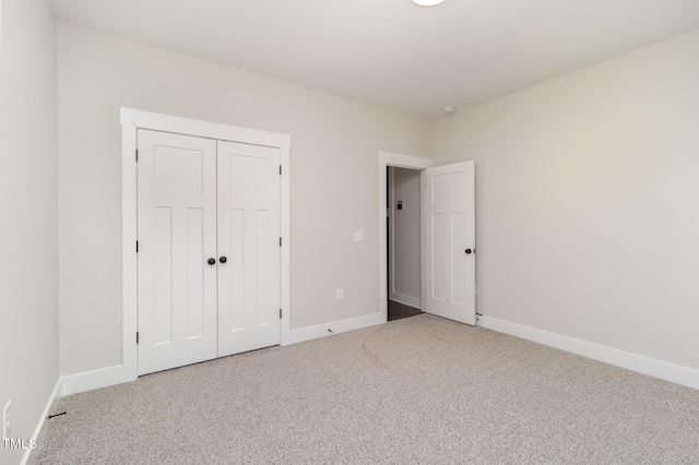 unfurnished bedroom with a closet, carpet, and baseboards