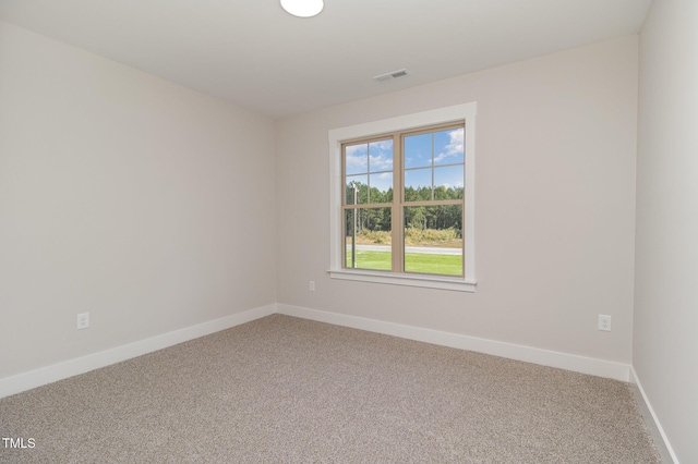spare room with light carpet, baseboards, and visible vents