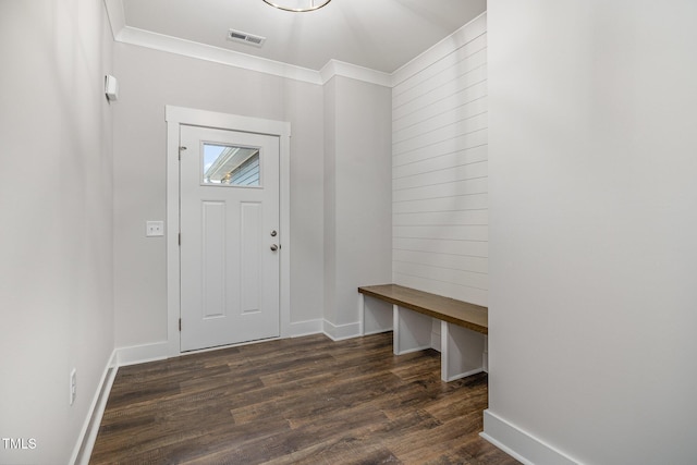 foyer with dark wood-type flooring, visible vents, baseboards, and crown molding