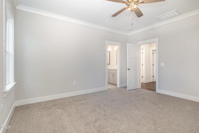 unfurnished bedroom with visible vents, baseboards, ensuite bathroom, ornamental molding, and carpet flooring