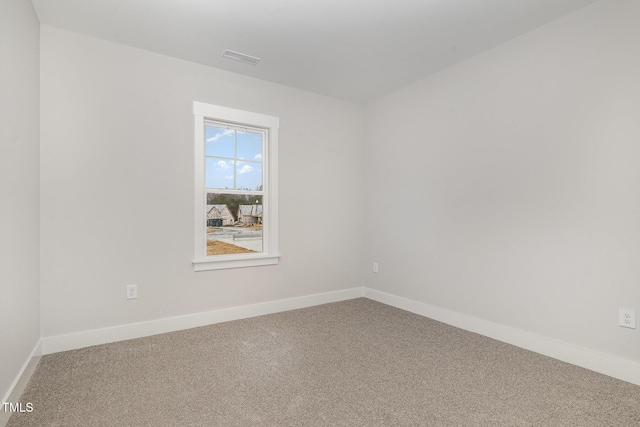 spare room featuring carpet flooring, visible vents, and baseboards