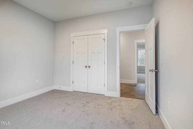 unfurnished bedroom featuring a closet, baseboards, and carpet