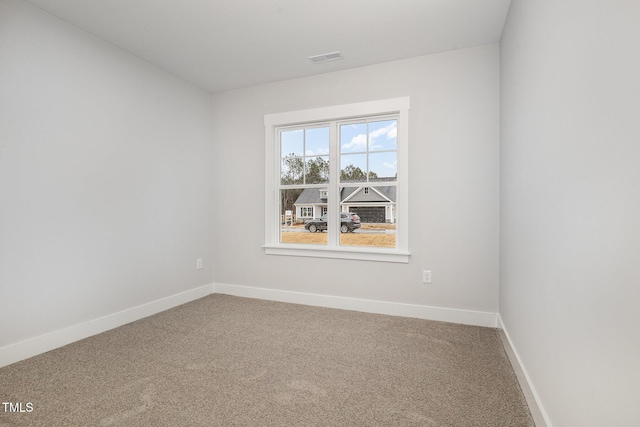 spare room featuring visible vents, baseboards, and carpet flooring