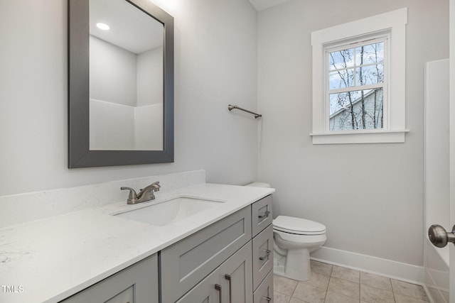 bathroom featuring toilet, vanity, baseboards, and tile patterned flooring