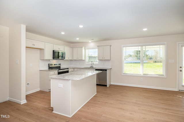300 Tuscany Cir, Princeton, NC 27569 - kitchen featuring tasteful backsplash, a kitchen island, stainless steel appliances, light wood finished floors, and a sink