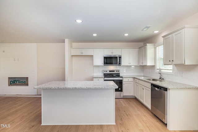 300 Tuscany Cir, Princeton, NC 27569 - kitchen featuring light wood-style flooring, a kitchen island, appliances with stainless steel finishes, a sink, and backsplash