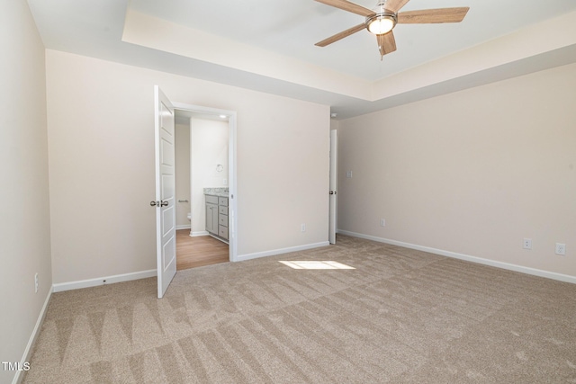 300 Tuscany Cir, Princeton, NC 27569 - unfurnished bedroom with a tray ceiling, baseboards, and light carpet