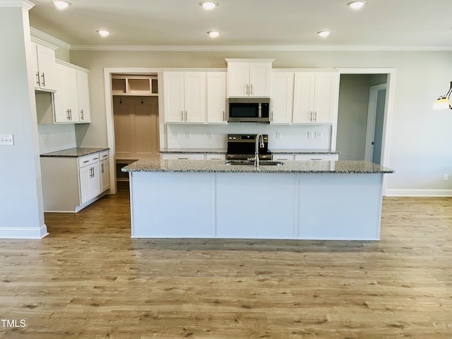 3912 Origin Dr, Bailey, NC 27807 - kitchen with stainless steel microwave, a sink, backsplash, crown molding, and dark stone counters