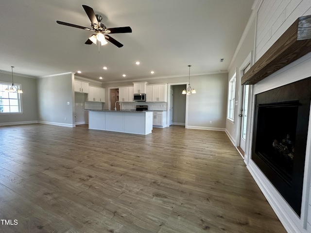 3912 Origin Dr, Bailey, NC 27807 - unfurnished living room featuring a chandelier, ornamental molding, baseboards, recessed lighting, and a sink