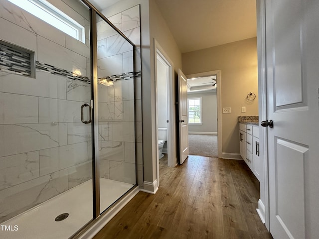 3912 Origin Dr, Bailey, NC 27807 - bathroom with wood-type flooring, toilet, baseboards, a shower stall, and vanity