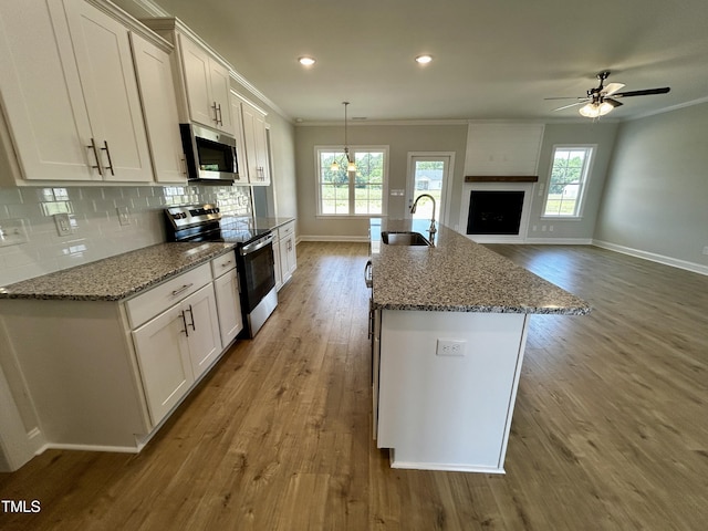 3912 Origin Dr, Bailey, NC 27807 - kitchen with stainless steel appliances, baseboards, a sink, wood finished floors, and crown molding