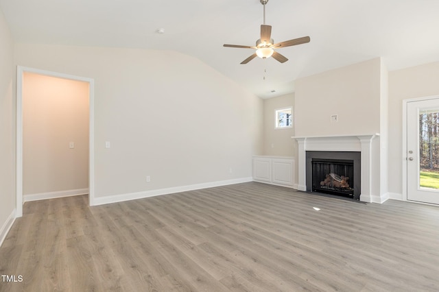 unfurnished living room featuring baseboards, a ceiling fan, a fireplace with flush hearth, light wood-style flooring, and lofted ceiling