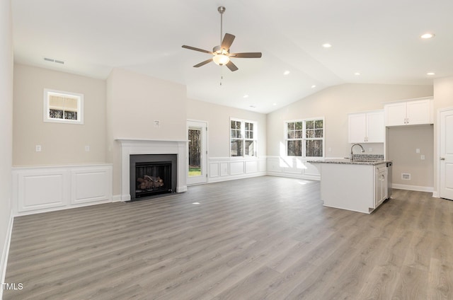 unfurnished living room featuring light wood-style floors, lofted ceiling, a ceiling fan, and visible vents