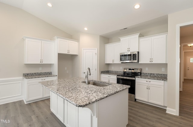 kitchen featuring visible vents, a sink, an island with sink, white cabinetry, and stainless steel appliances