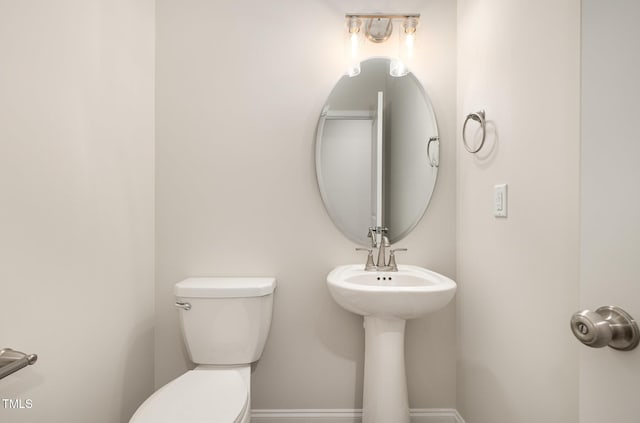 half bath with baseboards and toilet