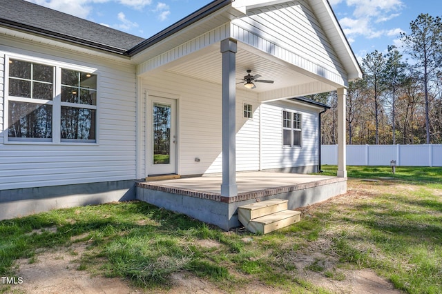 back of property with a patio, a lawn, a ceiling fan, fence, and a shingled roof