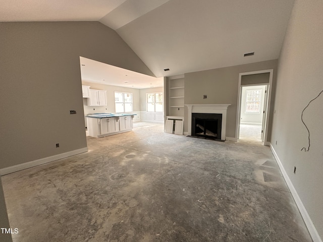unfurnished living room with a fireplace with flush hearth, lofted ceiling, visible vents, and baseboards