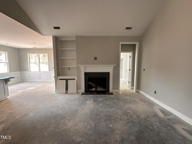 unfurnished living room featuring a fireplace with flush hearth, vaulted ceiling, and visible vents