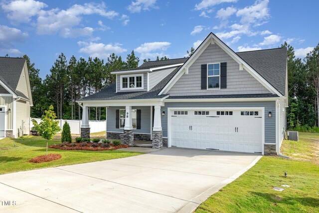 98 Laramie Ln, Selma, NC 27576 - craftsman house featuring stone siding, driveway, covered porch, and a shingled roof