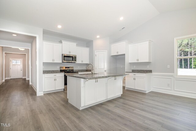98 Laramie Ln, Selma, NC 27576 - kitchen with appliances with stainless steel finishes, lofted ceiling, white cabinets, light wood finished floors, and recessed lighting