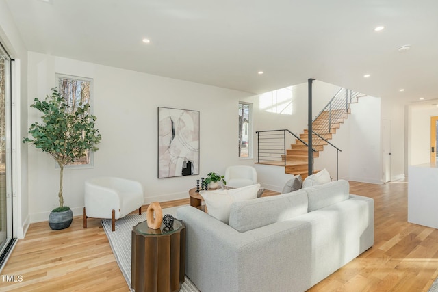 living room featuring light wood-style floors, baseboards, stairway, and recessed lighting