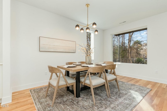 dining room featuring baseboards, visible vents, and light wood-type flooring