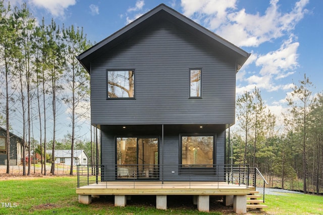 rear view of house featuring a deck and a yard