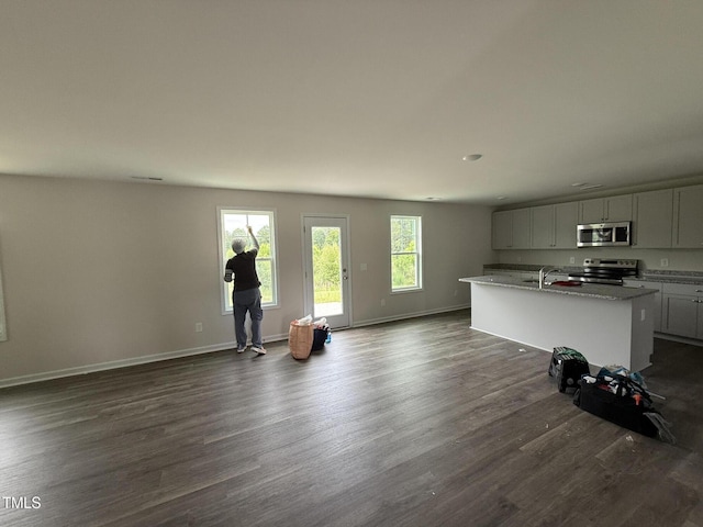 43 Chloe Ct, Selma, NC 27577 - unfurnished living room featuring dark wood-style floors, baseboards, and a sink